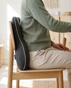 Seated at a desk with the lower back supported in its natural curve